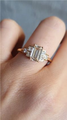 a woman's hand with an engagement ring and three stone diamond band on it