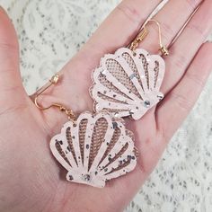 "Dainty and adorable, these soft and flexible Seashell Faux Leather Textured Earrings are the perfect little gift for most occasions such as:  A simple gift for her, Christmas, Birthdays, Anniversary's, Valentine's Day, gifts and many more! Each leaf is cut on soft flexible rose gold and pink with silver speckles textured faux leather with a soft felt-like light white fabric on the back, and are hanging on surgical steel earring hooks with transparent earring backers. Featured are also swarovski crystal rhinestones which really give these earrings that extra glitter and sparkle you need to light up the room! SIZING: Seashell cutouts are approximately 1.5\" X 1.5\" Overall approximate length of earring when worn is 2.25\" If you are interested in a different color, please reach out prior to Nickel-free Shell Gift, Trendy Shell-shaped Jewelry Gift, Nickel-free Ocean-inspired Shell As Gift, Ocean-inspired Shell Earrings As Gift, Trendy Shell-shaped Jewelry As A Gift, Cute Adjustable Earrings For Beach, Cute Adjustable Earrings For The Beach, Trendy Shell Jewelry For Gifts, Dangle Shell Earrings Gift