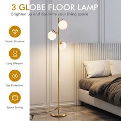 the three globe floor lamp is next to a bed