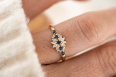 a woman's hand with a diamond and sapphire ring