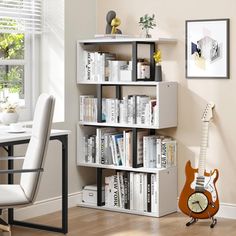 a room with a guitar, bookshelf and desk