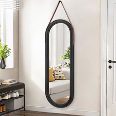 a mirror hanging on the wall next to a couch in a room with white walls