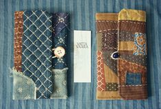 three pieces of fabric with buttons on them sitting next to a card holder and tag