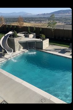 an outdoor swimming pool with a slide in the middle and water running down it's side