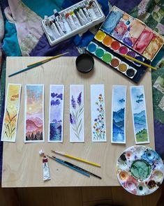 some watercolors are sitting on a table next to an artist's palette