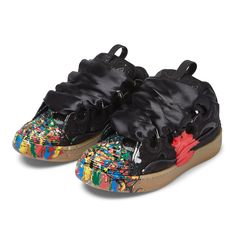 a pair of black shoes with multicolored fabric and bows on the top, side view