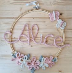 a hoop with the word peace written in crochet and decorated with flowers on it