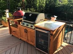 an outdoor bbq grill on a deck next to a pool