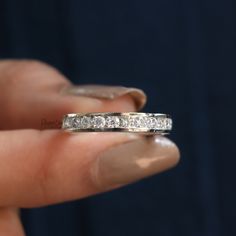 a woman's hand holding a diamond ring