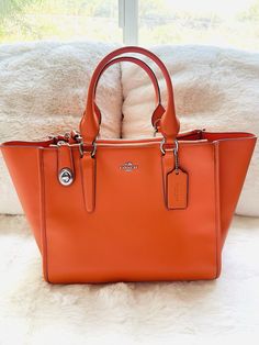 Coach Crosby Carryall in Smooth leather crossbody tote bag in orange brand new with tag, this bag is almost in perfect condition, was never touched or used. Comes with original dust bag . There are two ways of shaping this bag, very versatile! roomy and elegant. COACH STYLE # 59183E Details Calf leather Inside zip, cell phone and multifunction pockets Zip-top closure, fabric lining Handles with 6" drop Long strap with 22" drop for shoulder or crossbody wear 17" (L) x 9 3/4" (H) x 7" (W) MSRP $395.00 This is not an outlet item, high quality of everything. Classic Orange Top Handle Satchel, Designer Orange Satchel For Shopping, Orange Satchel With Detachable Handle For Shopping, Classic Orange Shoulder Bag With Top Carry Handle, Classic Orange Satchel Bag, Designer Orange Satchel For Travel, Modern Orange Crossbody Bag, Designer Orange Top Handle Satchel, Modern Coach Satchel With Handle Drop