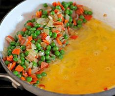 peas and carrots are mixed together in a skillet