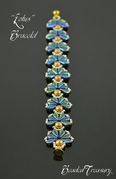 a beaded bracelet with blue and gold beads on it's side, sitting on a black surface