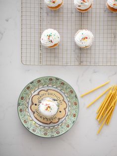 cupcakes with white frosting and sprinkles on a plate