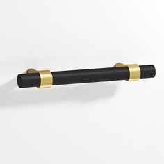 a black and gold handle on a white wall