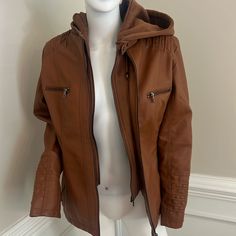 Faux Leather Jacket With Removable Jersey Hood In Luggage Color. Polyurethane Coated. 100% Polyester Shell And Lining. Condition New Without Tags Brown Leather Jacket With Zipper For Cold Weather, Leather Outerwear For Outdoor, Brown Leather Outerwear With Detachable Hood, Brown Leather Jacket With Double-lined Hood For Fall, Brown Hooded Outerwear With Zipper Closure, Brown Outerwear With Detachable Hood For Fall, Fall Brown Outerwear With Detachable Hood, Brown Fall Outerwear With Detachable Hood, Fall Travel Outerwear With Zipper Closure