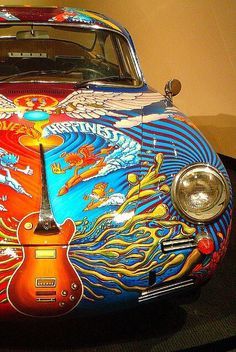 the front end of a colorfully painted car on display in a museum exhibit room