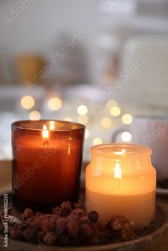 two lit candles sitting on top of a plate