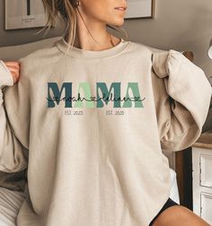 Celebrate motherhood with our Personalized MAMA Hoodie, customized with your children's names and their birth years for a truly special touch. This cozy MOM sweater makes a thoughtful and heartfelt gift for expectant mothers, baby showers, or as a memorable Mother's Day tribute. ♥PRODUCTION TIME: 1-5 days (usually 2-3 days) ♥SHIPPING TIME: 2-5 days (usually 3 days) ♥PRODUCT DESCRIPTION: Gildan Crewneck Unisex Sweatshirt Super soft cotton and excellent quality print makes. 50% cotton and 50% polyester (fibre content may vary for different colors) Medium-heavy fabric (8.0 oz/yd² (271.25 g/m²) Runs true to size Our Relaxed Fit Sweatshirt (Gildan 18000) is a unisex style that runs a touch small for men, and about a half a size large for women. It's a relaxed fit and is soft and cozy. * For Swe Mama Sweater, Mama Hoodie, Mom Sweater, Birth Gift, Workout Sweatshirt, Sweater Making, Unisex Style, Kid Names, Heavy Fabric