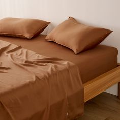 a bed with brown sheets and pillows on it