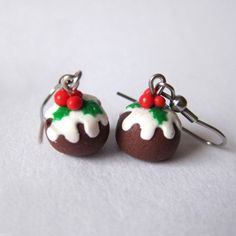 two chocolate covered desserts with white icing and red berries