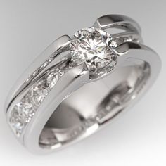 a white gold ring with diamonds on the side and a diamond set in the middle