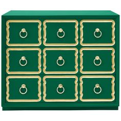 a green and gold chest of drawers with rings on each drawer, one door open