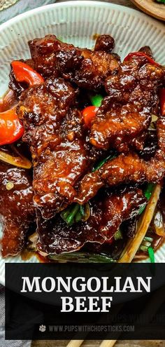 the beef dish is served on a plate with chopsticks and sauce in it