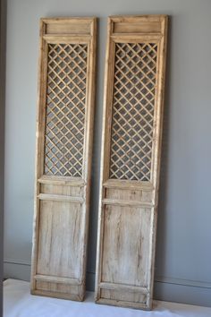 two wooden doors sitting next to each other on top of a white sheeted floor