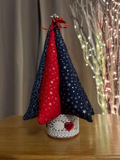 a small christmas tree with red, white and blue decorations on it's top