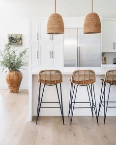 three wicker stools sit at the kitchen island