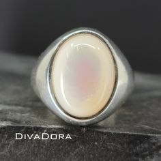 "ITEM DETAILS Item #: SROS6 Metal: 925 Sterling Silver Finish: Brushed or Polished Item Dimensions: Top Length: 20mm Top Width: 14mm Shank Base Width: 6mm Gemstone: Mother of Pearl Center stone: 16mm x 12mm ----------------------------------------------------- ✨ CUSTOMIZE YOUR RING! Looking for different options for your ring? We can personalize this band for you with all of the below options. Simply message us for a custom quote and we will get back to you right away. *Available metals: 925 Sterling Silver, 14K Solid Gold, 18K Solid Gold, Platinum, Palladium. *Available metal colors: Silver, White Gold, Yellow Gold, Rose Gold, and Gray Gold. *Available finishes: polished, brushed, hammered, sand-blasted matte, milgrain. ----------------------------------------------------- 💍 UNSURE ABOUT Classic Oval Opal Ring With Polished Finish, White Oval Opal Ring With Polished Finish, Classic White Opal Ring With Polished Finish, Silver Signet Ring With Oval Cabochon Gemstone, Formal Sterling Silver Opal Ring Oval Cabochon, Formal Sterling Silver Opal Ring With Oval Cabochon, White Oval Opal Ring Hallmarked, Oval White Opal Ring Hallmarked, Classic White Oval Cabochon Ring