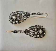 "Striking pair of English Victorian sterling and paste flower dangle earrings, circa 1840s - 1860s. The design is exquisite, comprised of a lovely daisy design of eight heart shaped petals with a larger round paste stone in the middle. There are also eleven more paste stones on the top of the earring. Materials - Sterling silver, paste stones and gold wire. Weight is 9.59 grams. Hallmarks - None. Condition - Very good antique condition. All stones are sparkling and clear. Measurements - Earrings Antique Drop Earrings With Historical Design, Antique Pierced Earrings For Wedding, Victorian Style Pierced Earrings For Wedding, Antique Wedding Earrings With Historical Design, Vintage Rose Cut Diamond Earrings, Historical Design Earrings For Wedding, Traditional Wedding Earrings With Historical Design, Traditional Earrings With Historical Design For Wedding, Traditional Historical Design Earrings For Wedding