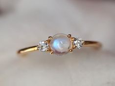 Rainbow moonstone ring, Moonstone engagement ring, stacking ring, Gold moonstone ring, Natural moonstone diamond ring, dainty promise ring Same design can be made also with other custom gemstones per request. Product details:- Solid gold (9k, 14k)- approx 5mm  moonstone round (AAA quality)- 2.5mm Diamonds ( G, VS-SI )- Band size is 1.4mm- Made to order - 8 to 10 business days.Ring size - US 3 to US 9 (for smaller or larger ring size, please contact)Please select your size at the drop down menu. Dainty Moonstone Engagement Ring, Moonstone Gold Ring, Promise Moonstone Ring With Rose Cut Diamonds, Delicate Moonstone Ring With Rose Cut Diamonds, Delicate Moonstone Diamond Ring, Dainty Moonstone Promise Ring, Moonstone Rings With Rose Cut Diamonds, Dainty Moonstone Diamond Ring In Yellow Gold, Dainty Yellow Gold Moonstone Diamond Ring