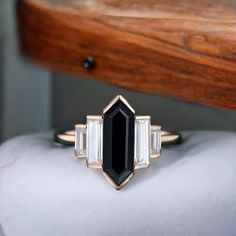 a black and white diamond ring sitting on top of a pillow