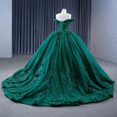 Embody elegance and sophistication in this dark green ball gown, perfect for a quinceañera or evening celebration. This dress is crafted from luxurious tulle, this dress has a stunning off-the-shoulder neckline that gracefully frames the shoulders and adds a hint of timeless romance. The voluminous ball-gown silhouette flows beautifully into a chapel-length train, giving you a majestic presence as you make your entrance. The intricate appliques and sparkling beadwork adorn the bodice and cascade Green Ball Gown With Sweep Train For Banquet, Elegant Quinceanera Dress With Sweep Train For Gala, Sleeveless Green Ball Gown For Evening, Sleeveless Green Evening Ball Gown, Green Ball Gown Quinceanera Dress For Wedding, Green Ball Gown With Sweetheart Neckline For Prom, Green Sweetheart Neckline Ball Gown For Party, Green Ball Gown With Sweep Train For Gala, Elegant Sleeveless Quinceanera Dress