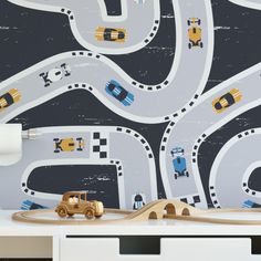 a child's play room with cars and roads painted on the wall next to a dresser