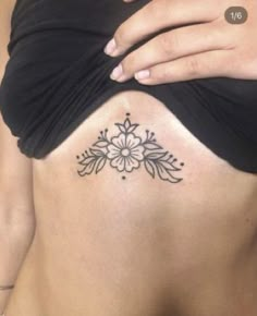 a woman's stomach with a flower tattoo on her belly and the bottom part of her abdomen