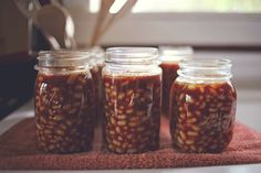 four jars filled with food sitting on top of a towel