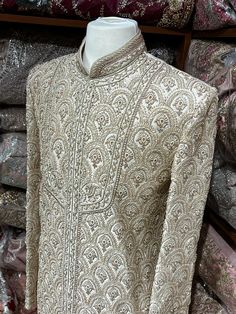 This beige white royal sherwani is brought into limelight with fine jaal embroidered coat enhanced with resham, pearl ,stone & cut dana work. The coat is styled with matching churidar pants. Size:40,42,44 Occasion: Wedding Ceremony or Reception WASH CARE INSTRUCTIONS - Please Dry clean only when it is applicable. Slight color variation is possible due to digital photography. Ready to Ship! Elegant Raw Silk Sherwani With Intricate Embroidery, Fitted Traditional Wear With Pearl Embroidery For Designer Wear, Elegant Raw Silk Bandhgala With Naqshi, Elegant Bandhgala With Naqshi In Raw Silk, Unstitched Pearl Embroidered Sherwani With Traditional Drape, Semi-stitched Pearl Embroidery Kurta For Reception, Elegant Designer Bandhgala With Resham Embroidery, Elegant Raw Silk Bandhgala With Intricate Embroidery, Elegant Sherwani With Pearl Embroidery For Diwali