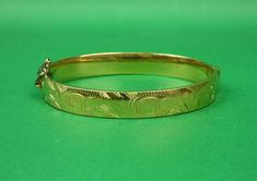 Description : A lovely Victorian style rolled gold bangle with very nice engraved decoration.  Engraved on one side only.  Secure hinge and safety chain. Marks : Marked Rolled Gold Guaranteed and with a heart motif Weight : It weighs 14.4 grams. Size :  5.5cm x 6.3cm.  1cm deep.  Internally approximately 17.5cm. Condition : In lovely condition.  Small dent to the back.  Some faint scratches. FREE UK POSTAGE. Formal Gold Stamped Bracelet, Gold Stamped Bangle Jewelry, Traditional Gold Stamped Bracelet, Gold Etched Bracelet, Gold Bracelet With Decorative Band As Gift, Gold Bracelets With Decorative Band As Gift, Gold Bangle Bracelet With Decorative Band As Gift, Gold Bangle With Decorative Band As Gift, Etched Round Gold Bracelet Gift