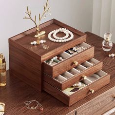 an assortment of jewelry sits on a wooden table next to other items and accessories, including bracelets