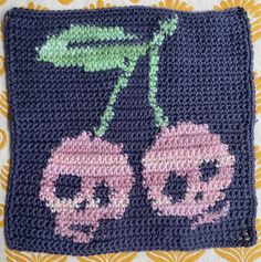 a crocheted square with an image of two pink flowers on top of it