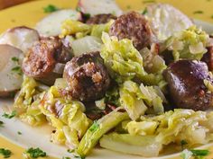 a yellow plate topped with meatballs and cabbage