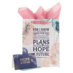 a small gift bag with a pink bow on it and a greeting card in front