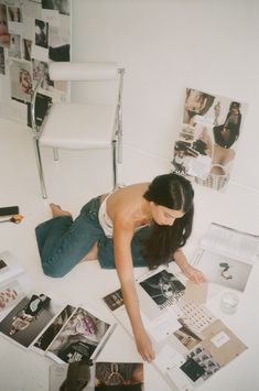 a woman laying on the floor surrounded by pictures