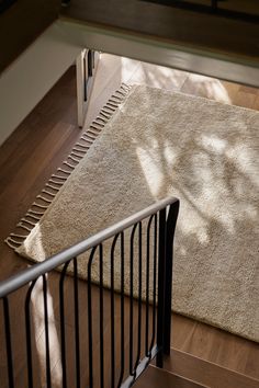 an area rug is placed on the floor next to a metal railing and stair rail