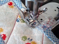 the sewing machine is on top of the quilted tablecloth with an applique