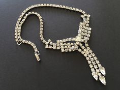 "Beautiful necklace signed Ledo - a company that created high quality jewelry during the 1950s. This necklace features a bow shaped centerpiece with tassels ending in pear shaped rhinestones. Great for a wedding or special occasion, this necklace has an elegant, well made feel. CONDITION/SIZE: In like new condition. This is a small necklace - just under 15\" long. Definitely choker length. LINKS: I carry a wide variety of items in my shop (growing by the day). Here are some links to popular cate Luxury Vintage Rhinestone Necklace, 1950s Jewelry Style, 50s Jewelry, Necklaces Wedding, 1950s Jewelry, Vintage Rhinestone Necklace, Vintage Wedding Jewelry, Art Deco Bracelet, Small Necklace