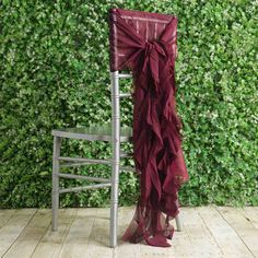 a chair with a bow on it sitting in front of a wall covered in ivy