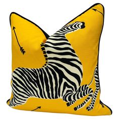 a yellow pillow with zebras on it and an arrow in the center, against a white background